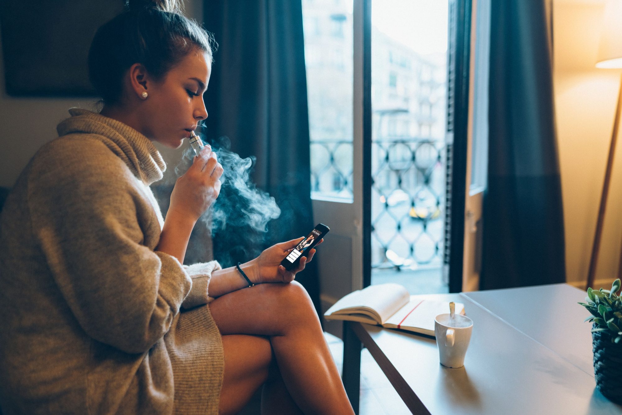 Girl vaping in her house.