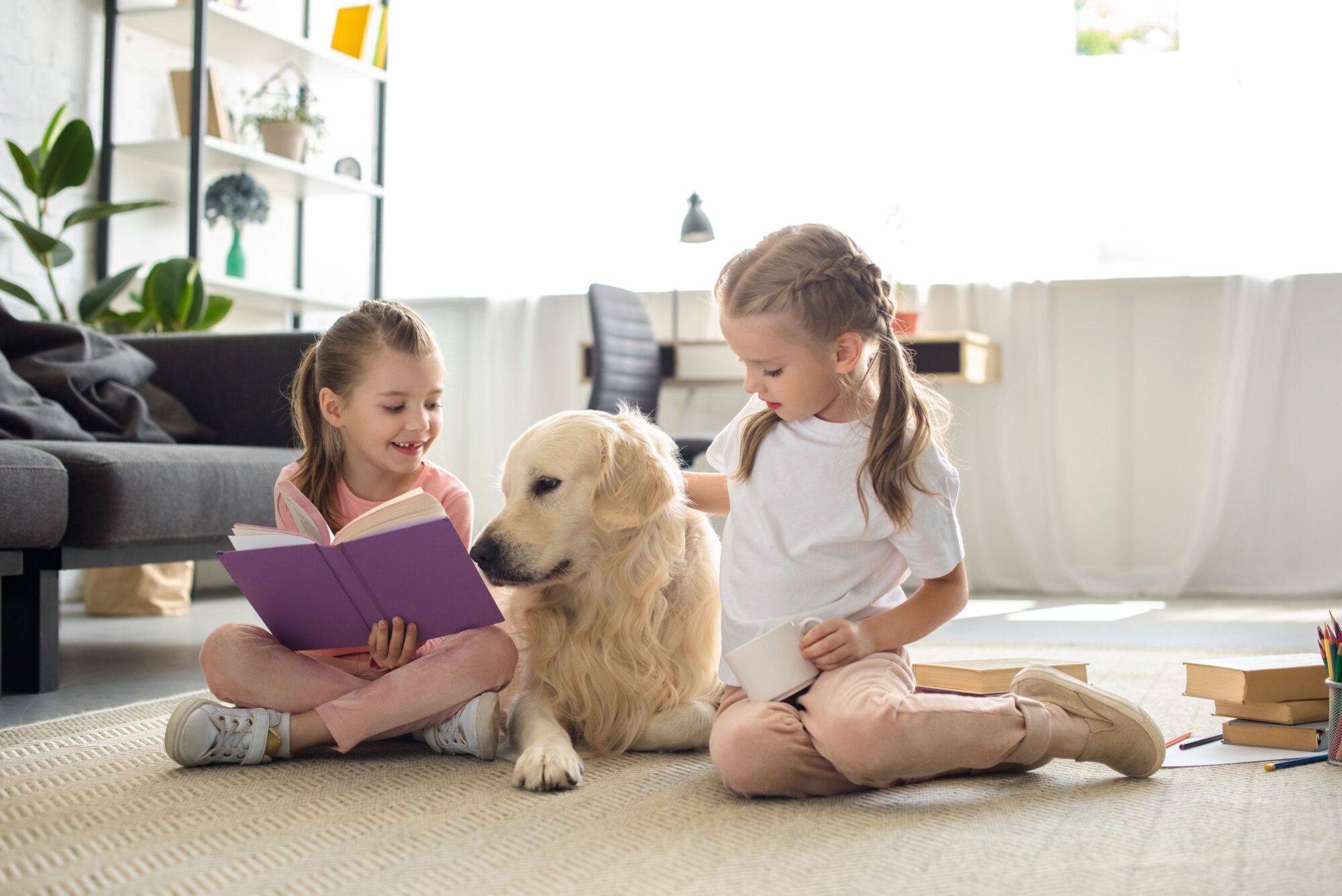 Little girls playing school with dog.